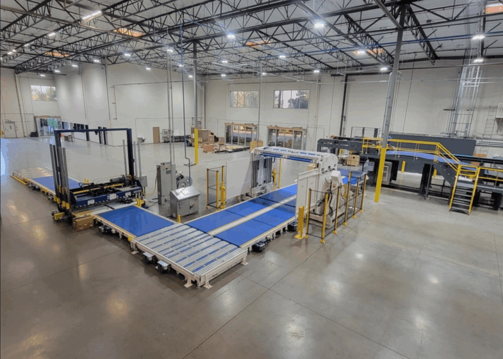 Automated material handling line of blue belt and roller conveyors running into a digital press